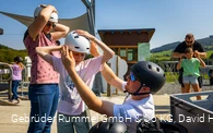 Familie setzt an der Sesselbahn Ritzhagen Helme auf für die Mountaincartstrecke 