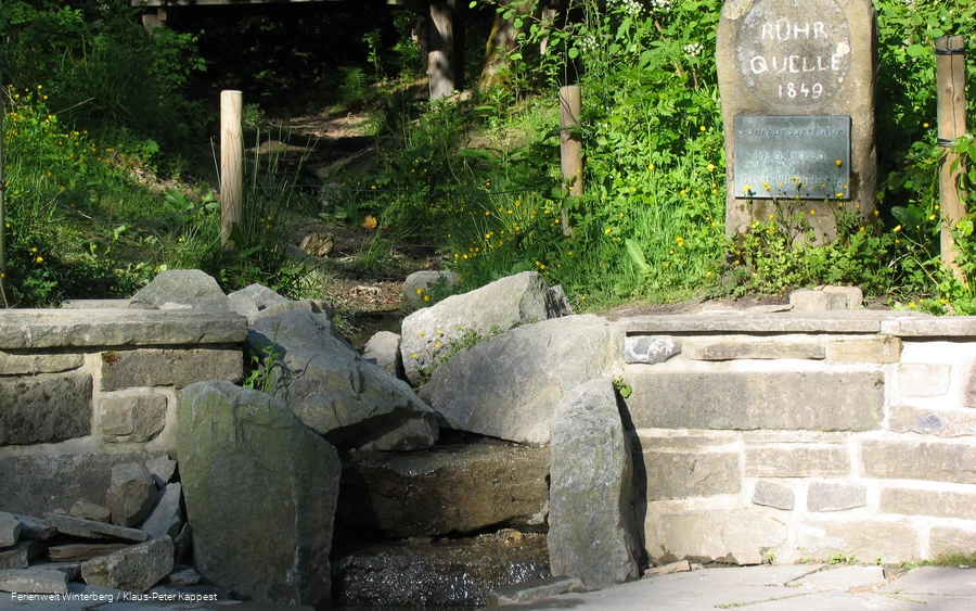 Nahaufnahme von Gesteinen, durch welche das hier entspringende Wasser der Ruhr hinabfließt.