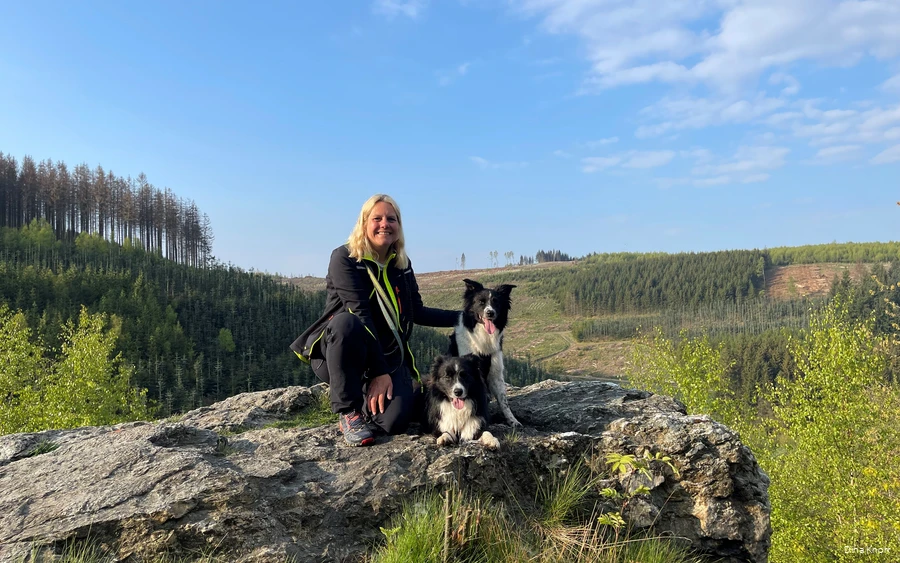 Dina Knorr in het Sauerland Blogger Dina Knorr poseert met haar twee honden tegen de achtergrond van het groene landschap van het Sauerland tijdens een van haar wandeltochten.