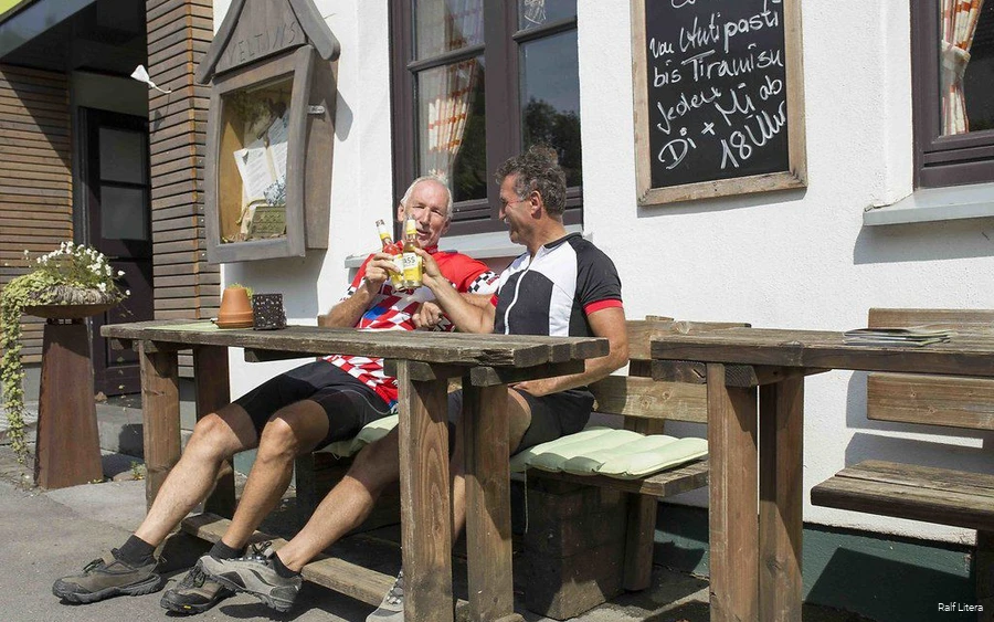 Zwei Radler machen Pause bei Steinbergs Wildewiese.