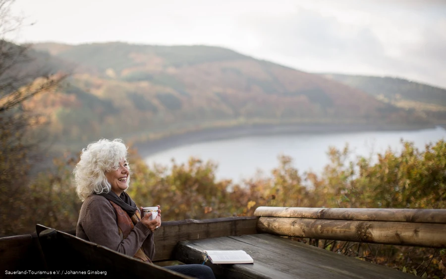 Lesen_Biggesee_Herbst Eine Frau entspannt beim Lesen in der Herbstlandschaft um den Biggesee.
