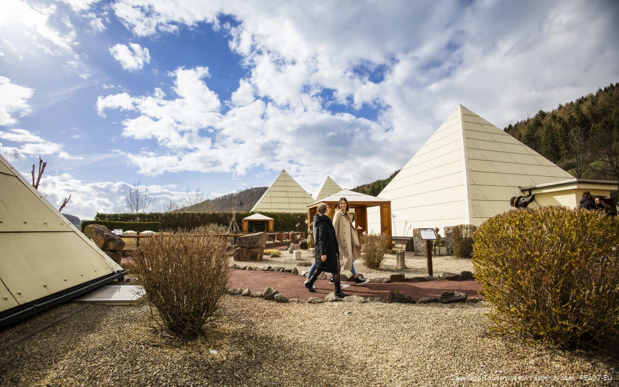 Zwei Frauen laufen zwischen den Pyramiden des Galileo-Parks und unterhalten sich.