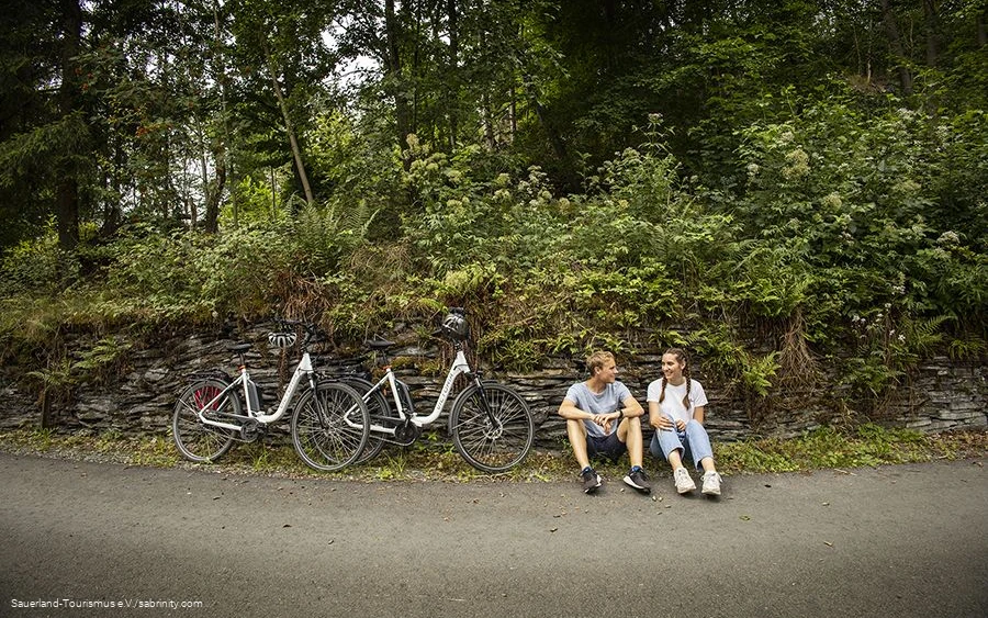 Een paar fietsers nemen een pauze langs de kant van de weg.