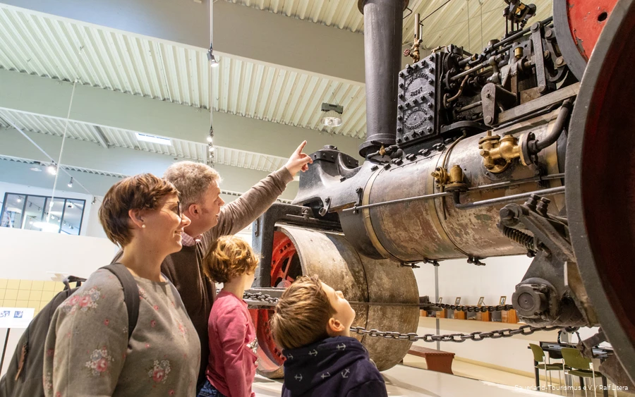 Vierköpfige Familie bestaunt alte Dampfmaschine im DampfLandLeute Museum in Eslohe.