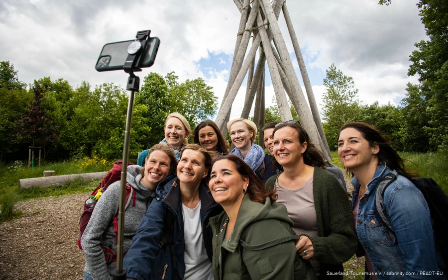 Eine Gruppe Frauen steht vor dem Kyrill-Tor in Brilon und posiert für ein Selfie.