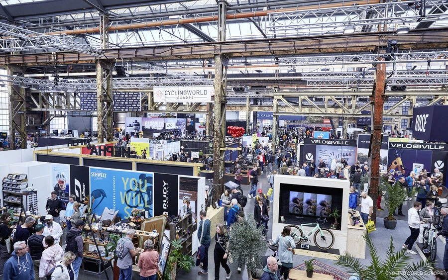 Volles Messegelände der Cyclingworld in Meerbusch in alter Industriehalle mit allerhand ausgestellten Fahrrädern und Zubehör.