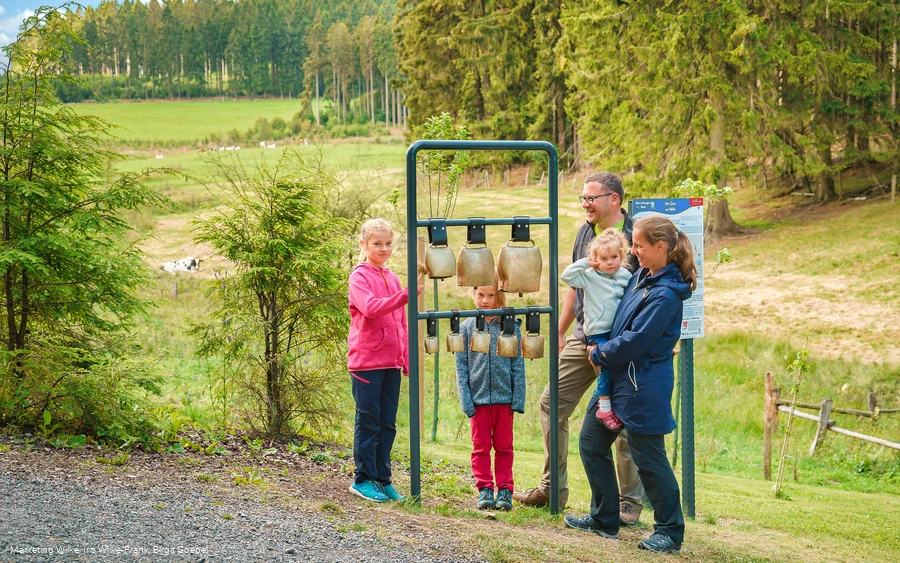 Familie am Kuhglockenspiel auf dem Milch-Erlebnispfad Usseln
