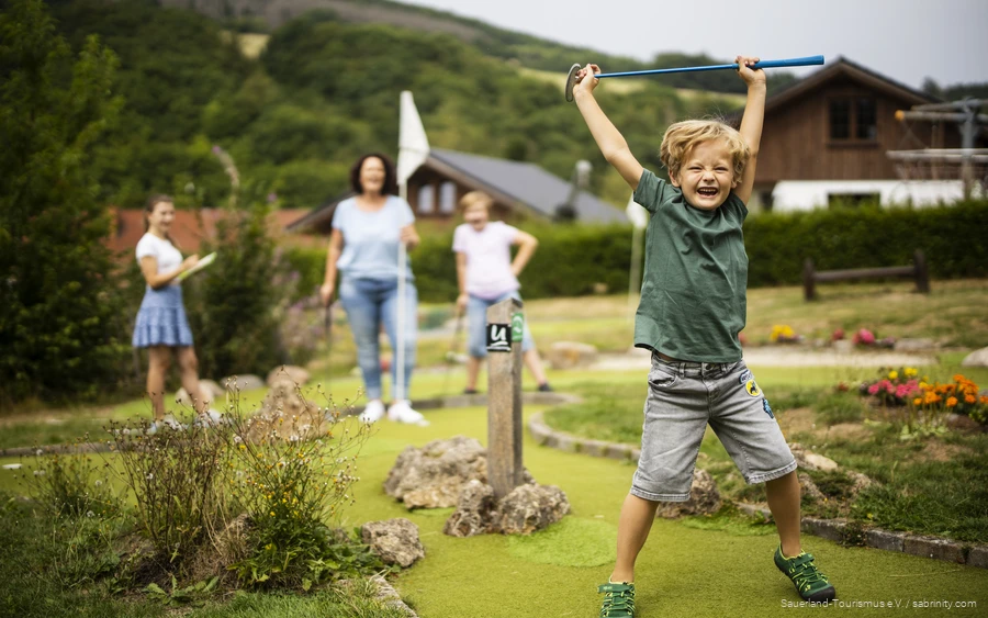 Familie macht einen Ausflug zum Minigolf im Sauerland