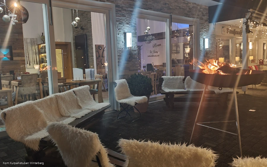 Einige im Halbkreis angelegte Sitzmöglichkeiten mit warmen Fellen mit einer brennenden Feuerschale in der Mitte.