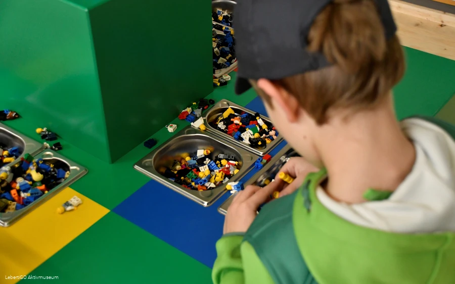 Ein Kind baut etwas aus kleinen Legosteinen.