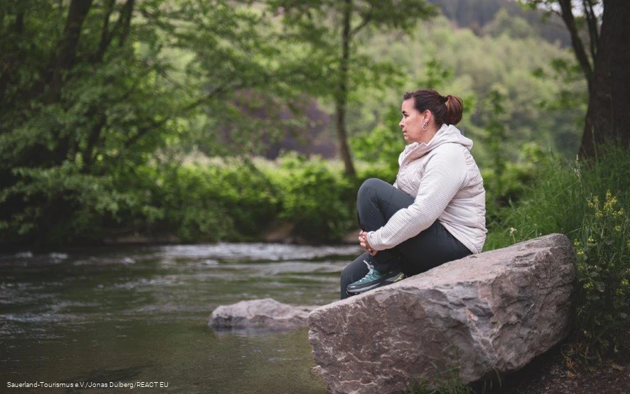 A woman looks into the rippling water at a Kneipp pool