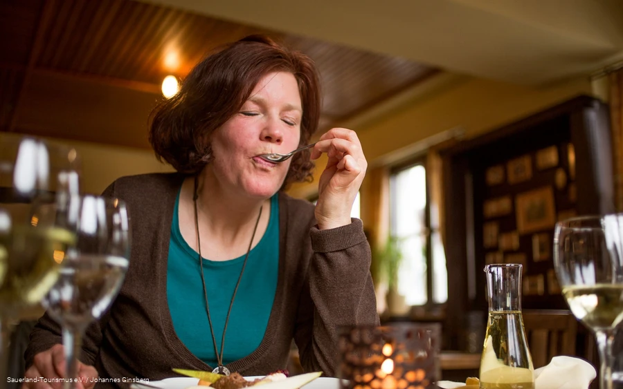 A woman enjoys her Essen in a Sauerland inn.