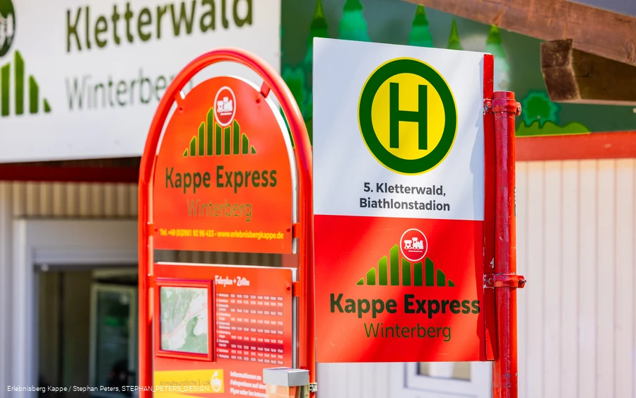 Ein Haltestellenschild mit der Aufschrift Kappe Express Winterberg und einem Fahrplan.