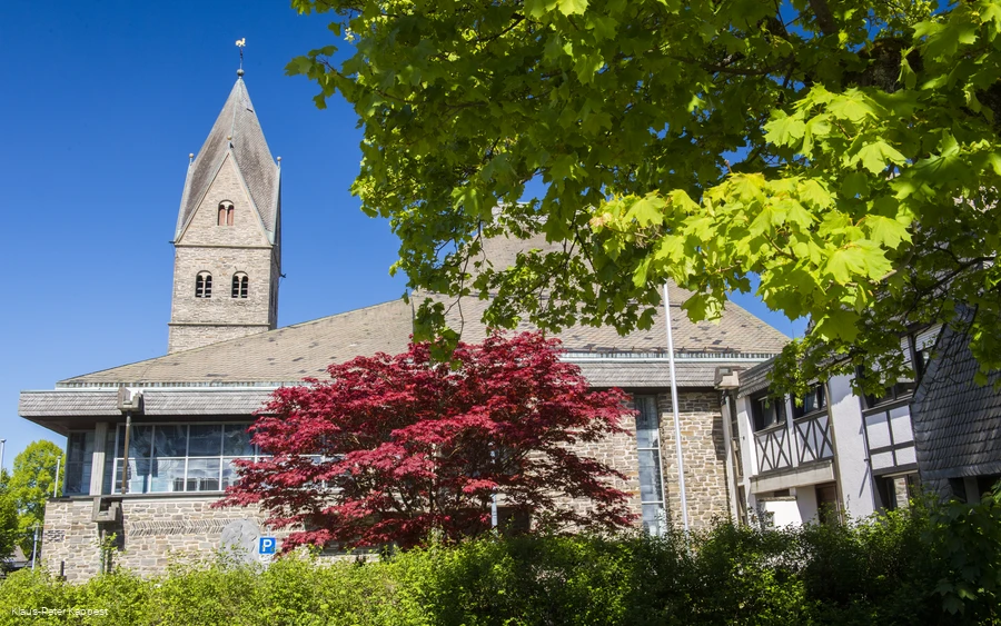 Eine Kirche vor blauem Himmel mit Bäumen im Vordergrund. Eine Kirche vor blauem Himmel mit Bäumen im Vordergrund.