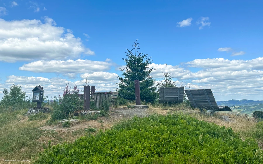 Aussichtsplatz mit mehreren Sitzmöglichkeiten und Informationstafeln.