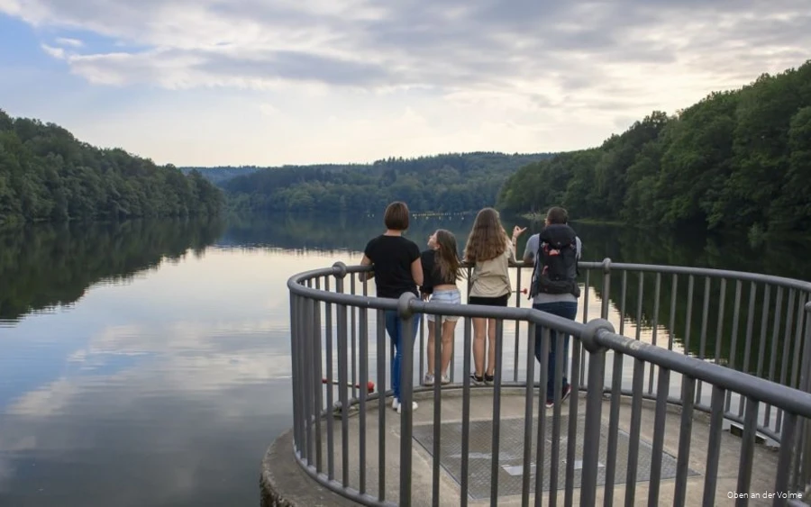Eine Familie steht auf einer Aussichtsplattform und schaut auf die Glörtalsperre.