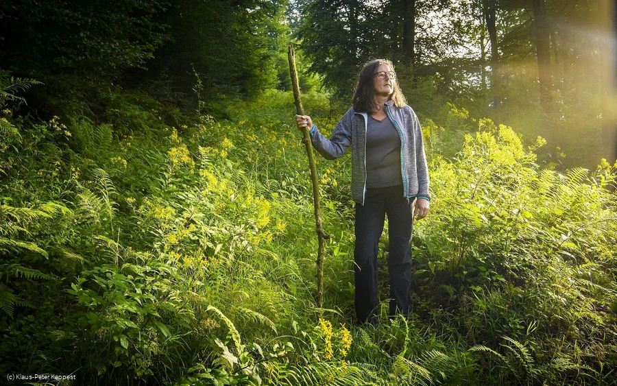 Frau mit Pilgerstab auf dem Uplaender Besinnungsweg