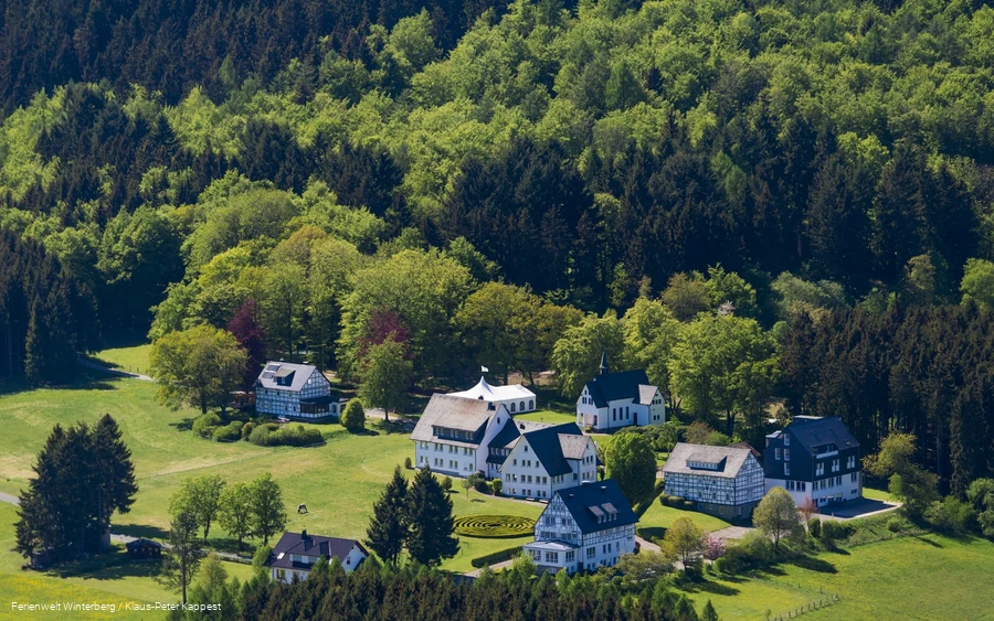 Eine Luftaufnahme einer kleinen Ansammlung von Häusern umgeben von Wäldern.