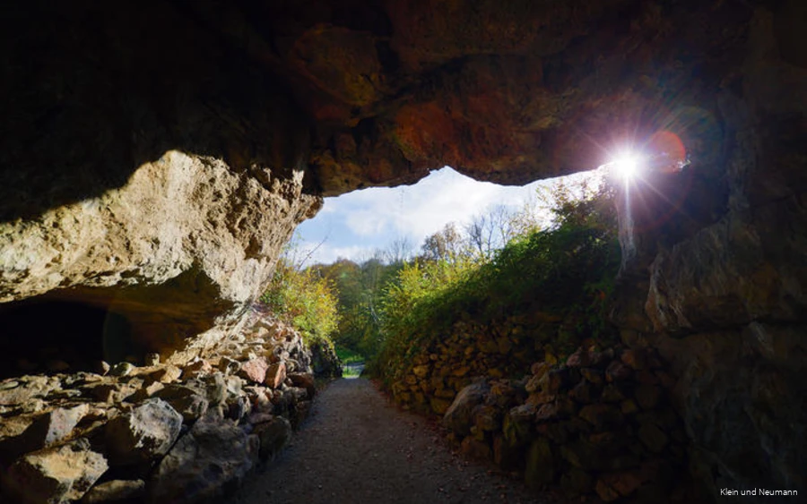 The sun shines into the entrance of the Reckenhöhle.