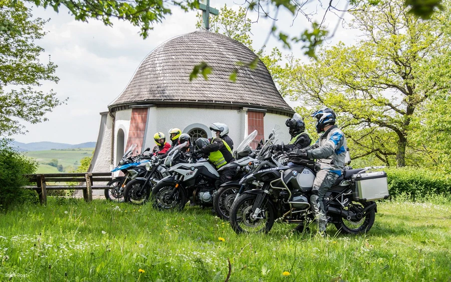 Motorrijders nemen een pauze bij de kapel boven Braunshausen.