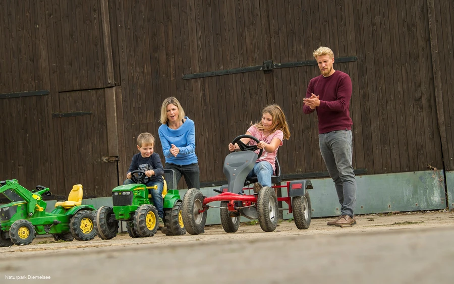 Kinder auf Spielzeugen auf dem Familienbauernhof Fass Kinder auf Spielzeugen auf dem Familienbauernhof Fass