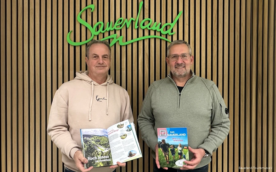 Jürgen Fischbach vom Sauerland-Tourismus und Pascal Möhrke vom Standpunkt-Verlag halten das fertige WAS IST WAS Buch in die Kamera.