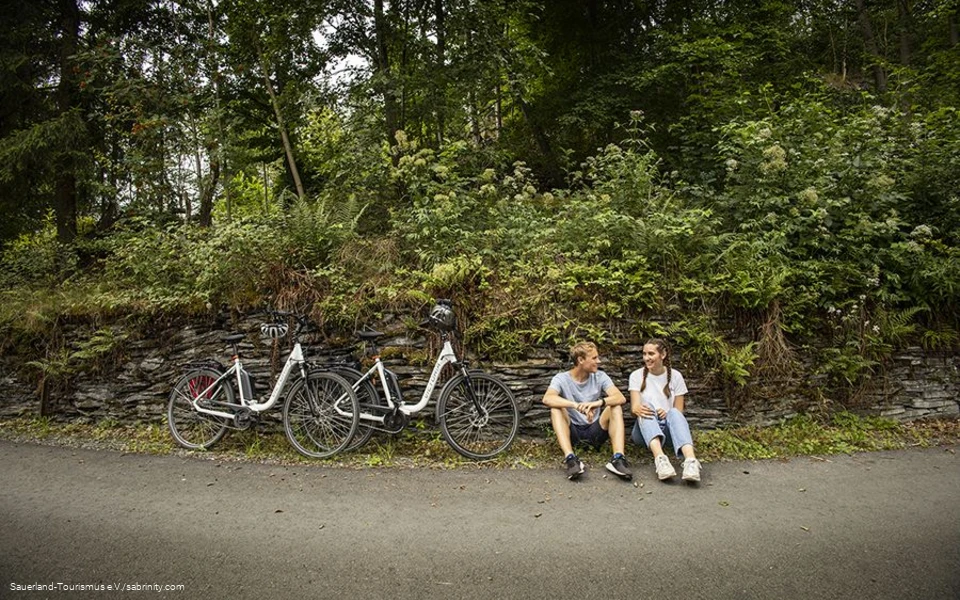 Radfahrerpärchen macht eine Pause am Wegesrand.