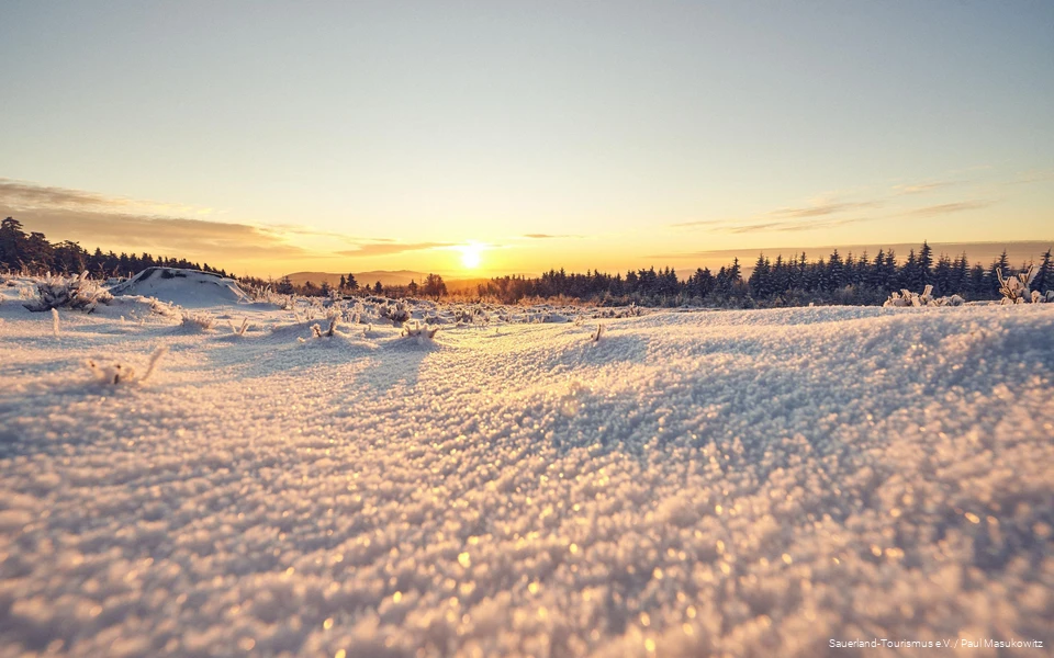 Sonnenaufgang über der verschneiten Sauerländer Landschaft.