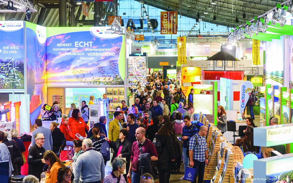 Eine Messehalle voller Informationsstände und Menschen