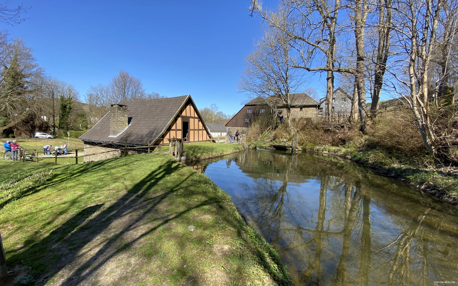 Das Geländer der Wendener Hütte auf einen Blick mit verschiedenen alten Gebäuden und dem Teich.
