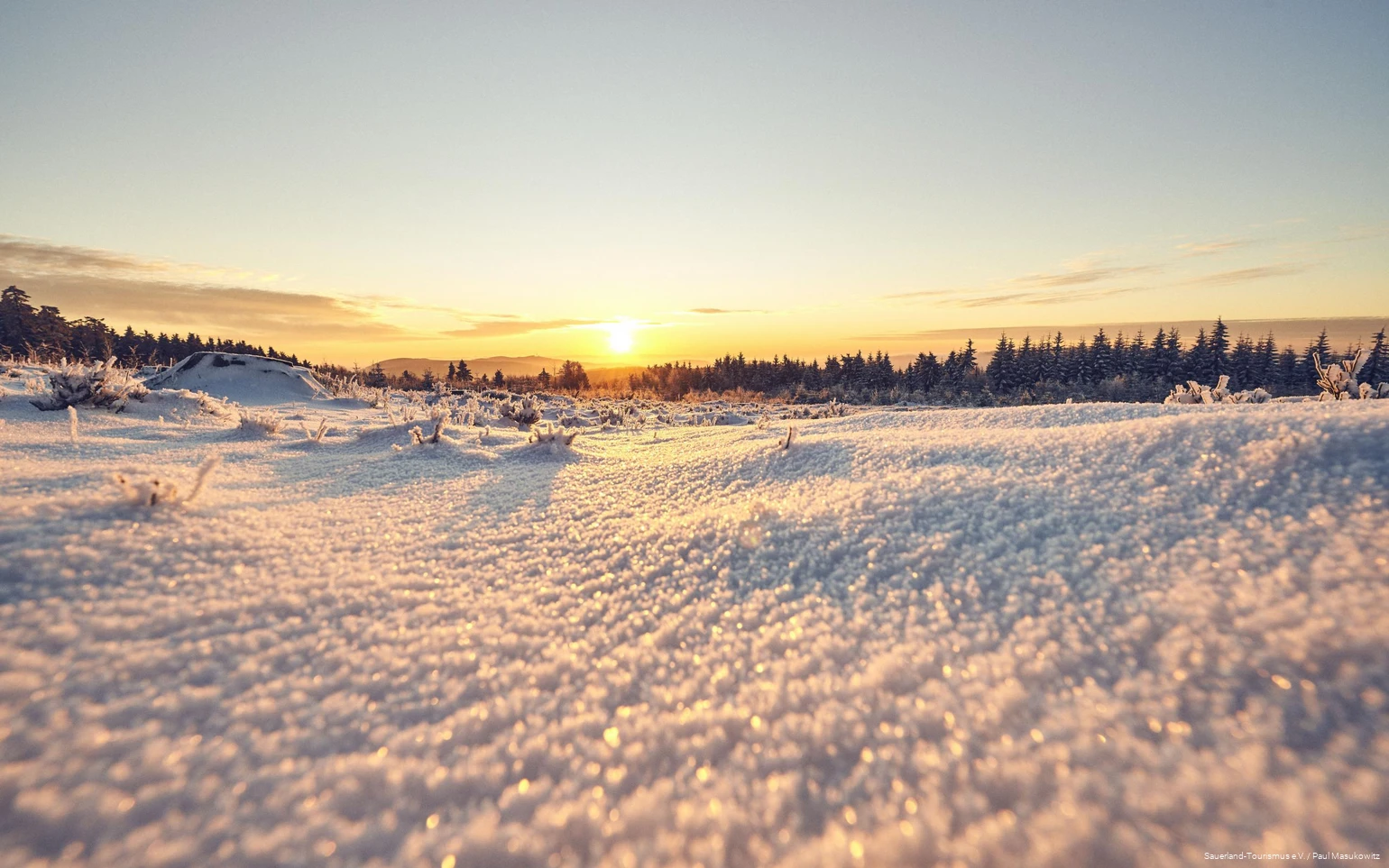 Sonnenaufgang über der verschneiten Sauerländer Landschaft.