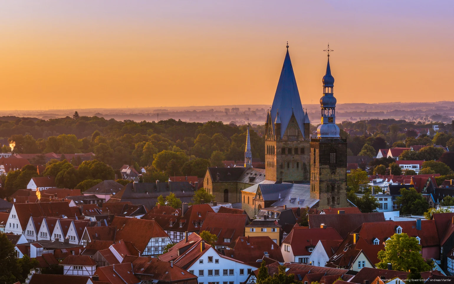 Aerial view of Soest with church in the center and orange sunset sky