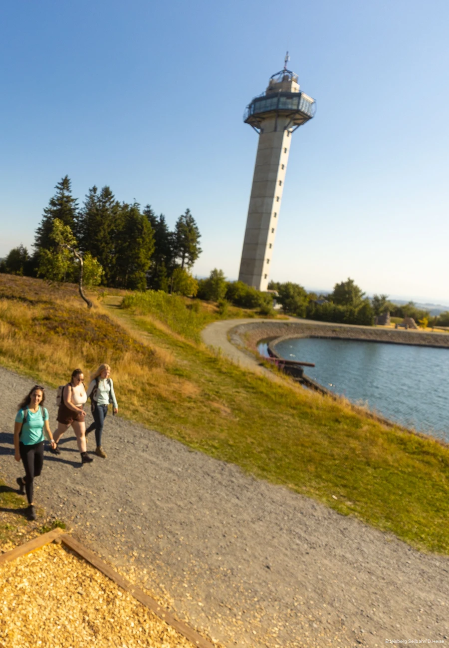 Hochheideturm auf dem Ettelsberg mit drei Wanderinnen im Vordergrund
