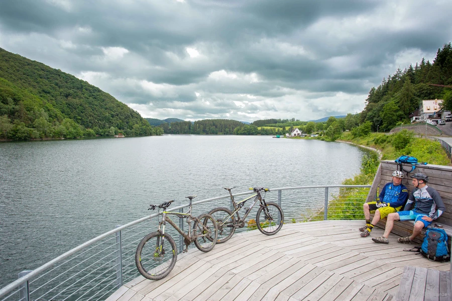 Zwei Mountainbiker machen Pause am Flussufer