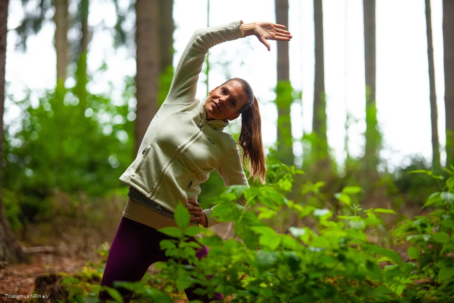 Een vrouw doet een oefening in het bos