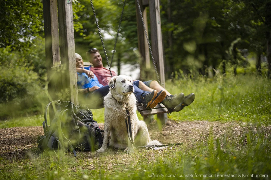 Urlauber mit Hund machen während einer Wanderung eine Pause. Sie wandern mit dem Hund auf den Wanderwegen im Sauerland