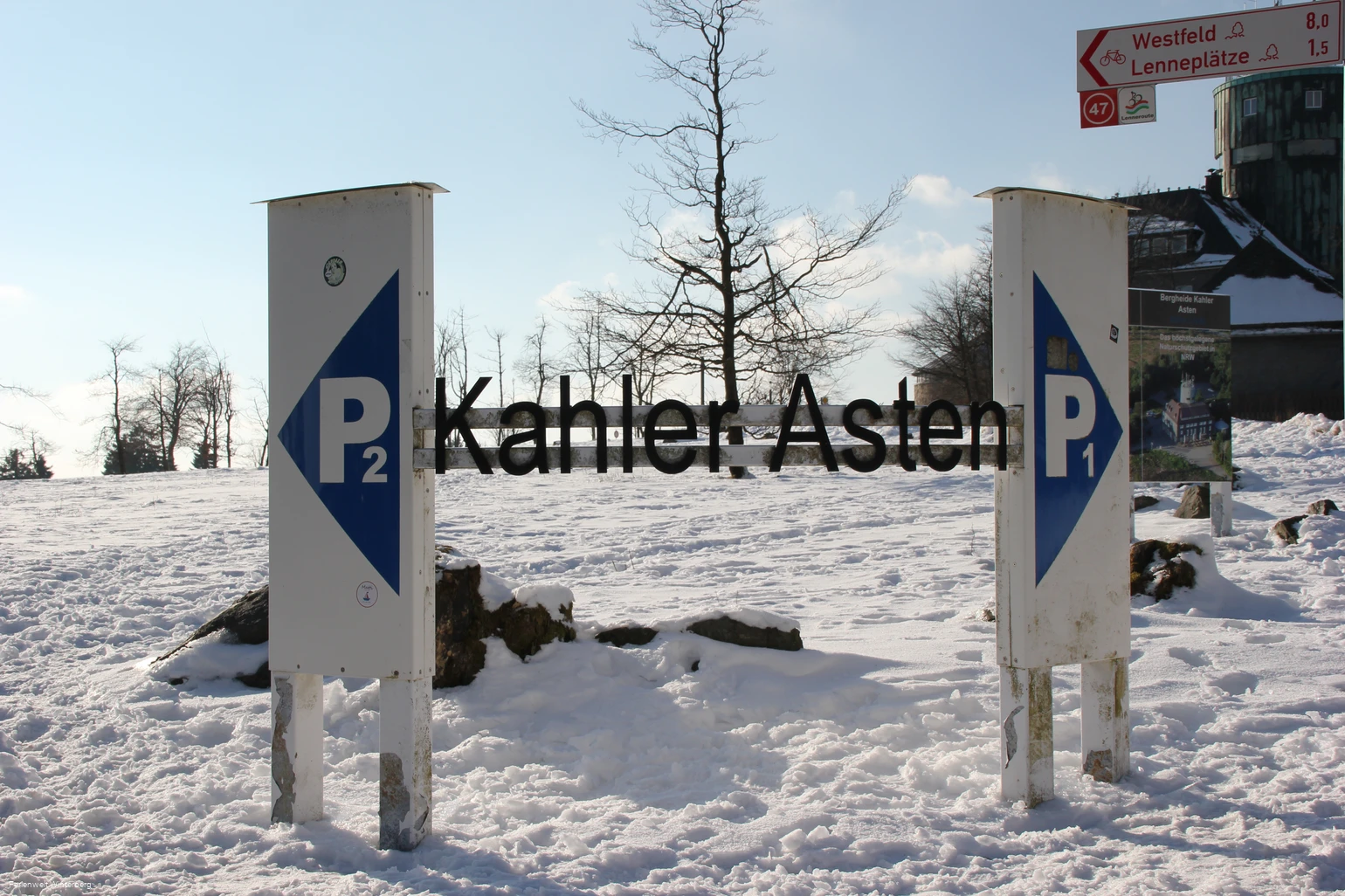 Zwei Parkplatzschilder mit der Aufschrift P1 und P2 in verschneiter Umgebung und dazwischen der Schriftzug Kahler Asten.